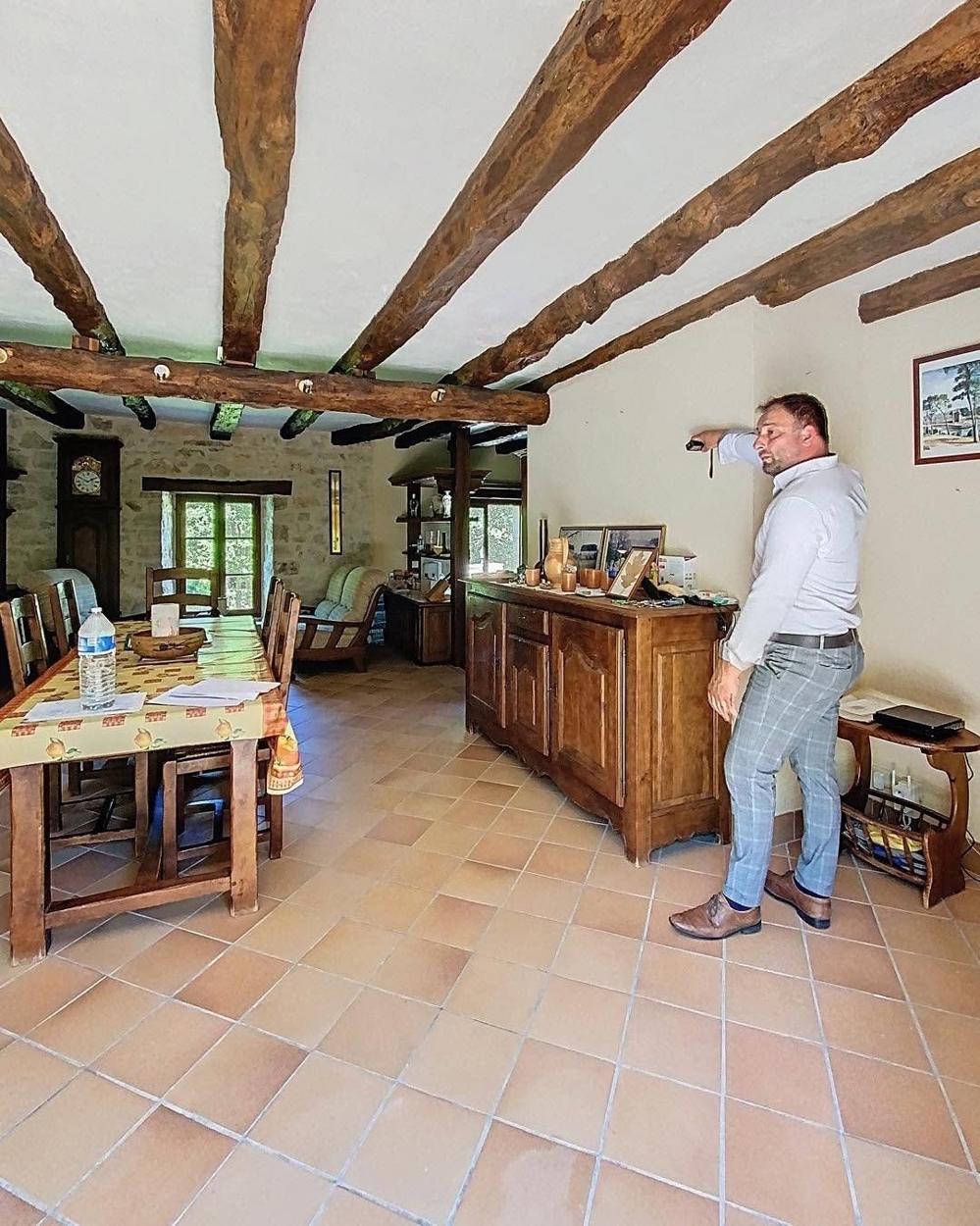 Stéphane Poree mesurant une fissure dans une maison ancienne
